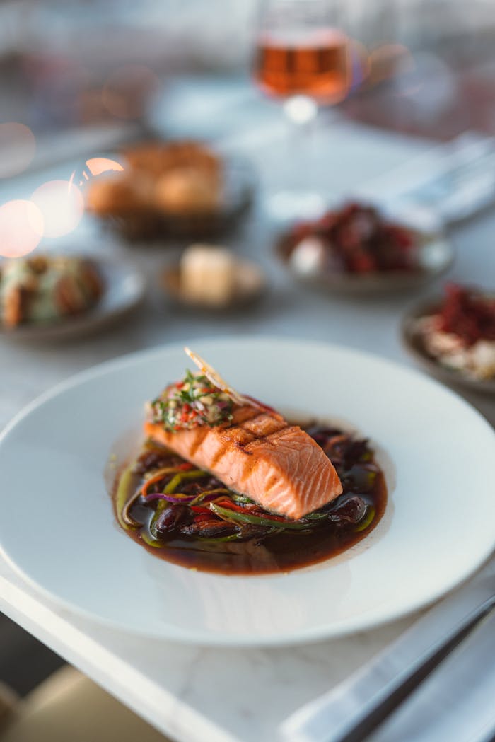 Fresh salmon fillet served with vegetables in a gourmet restaurant setting.